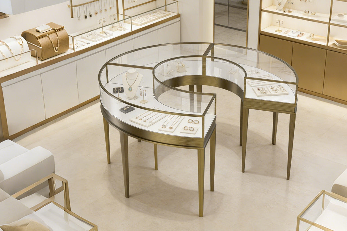 Jewelry display case in a store with various jewelry items on a curved glass counter.